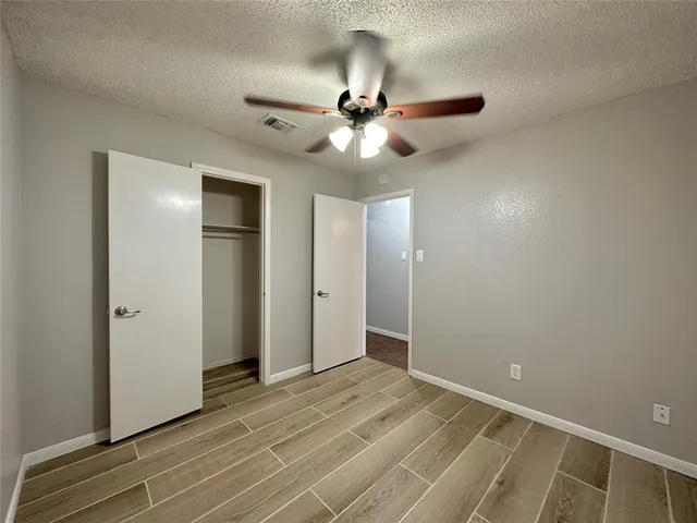 a view of an empty room and window with a chandelier fan