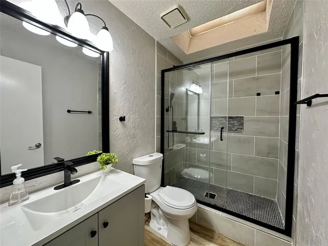 a bathroom with a sink toilet a mirror and shower