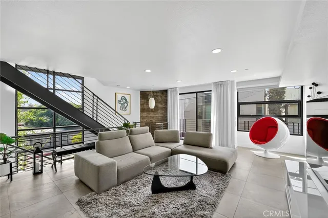 a living room with furniture a rug and a large window