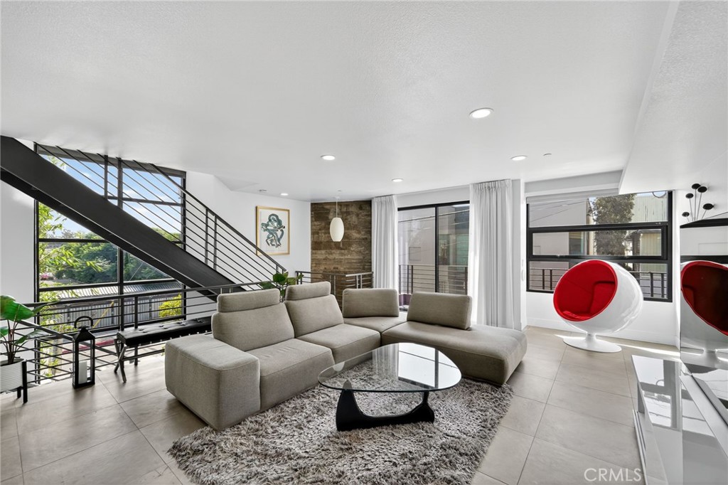 a living room with furniture a rug and a large window