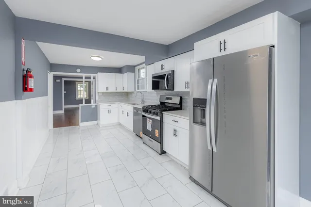 a kitchen with stainless steel appliances granite countertop a refrigerator and a stove top oven