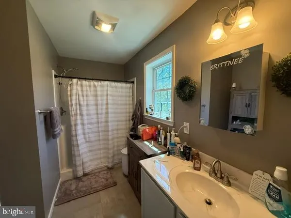 a bathroom with a sink vanity and a mirror