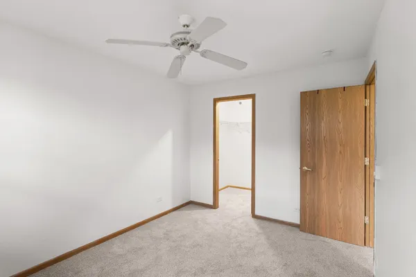 an empty room with a ceiling fan and a window