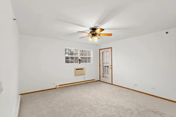 an empty room with a window and a ceiling fan