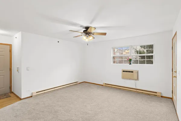 an empty room with windows and ceiling fan