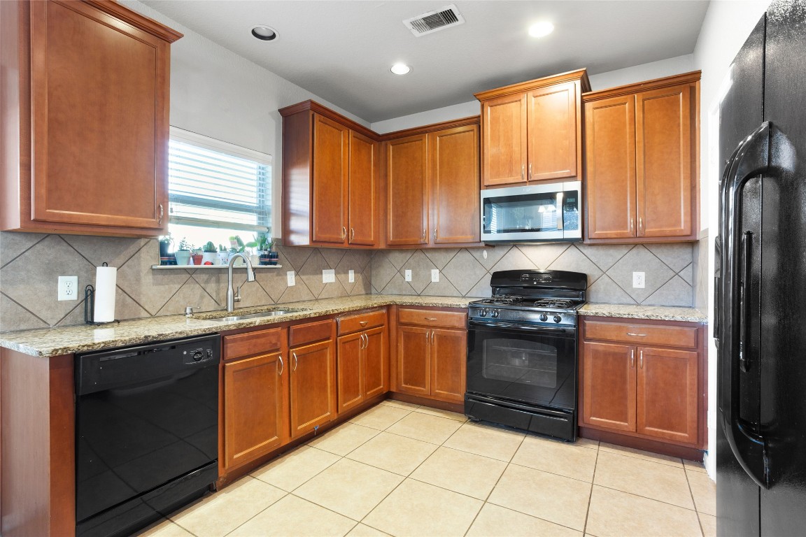 30 Supiro Drive Manvel, TX 77578 - Photo 9 of 30 a kitchen with stainless steel appliances granite countertop a stove sink and cabinets