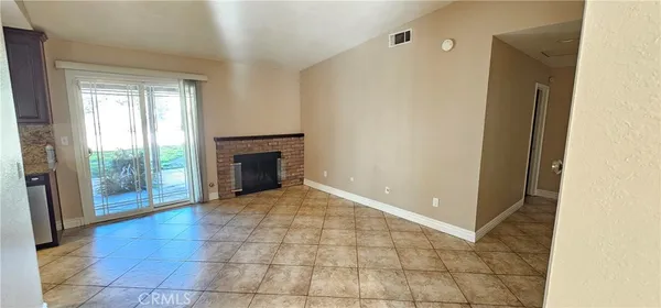 a view of a hallway to an empty room and window