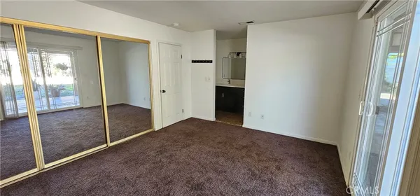 an empty room with windows and closet