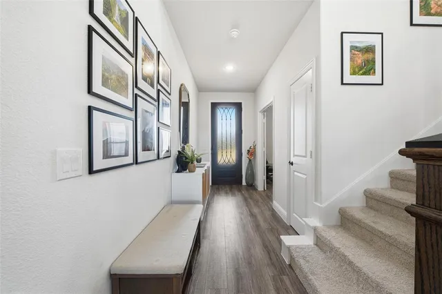 a view of a hallway with wooden floor and staircase