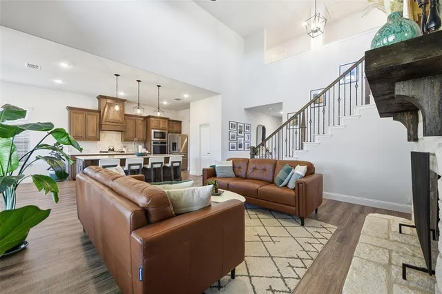a living room with furniture kitchen view and a wooden floor