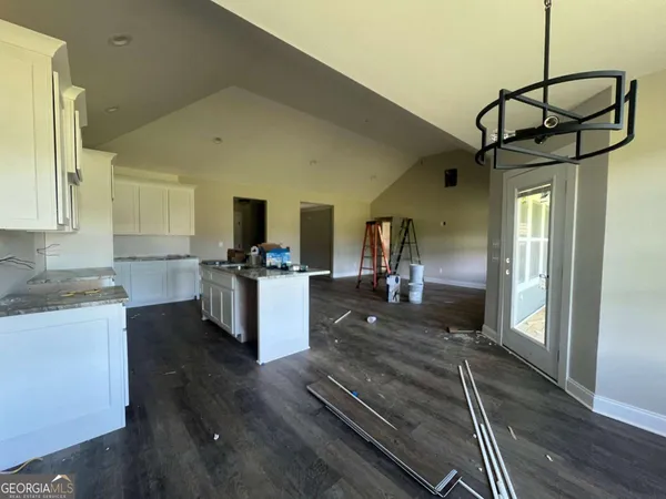 a kitchen view with wooden floor and a view of living room