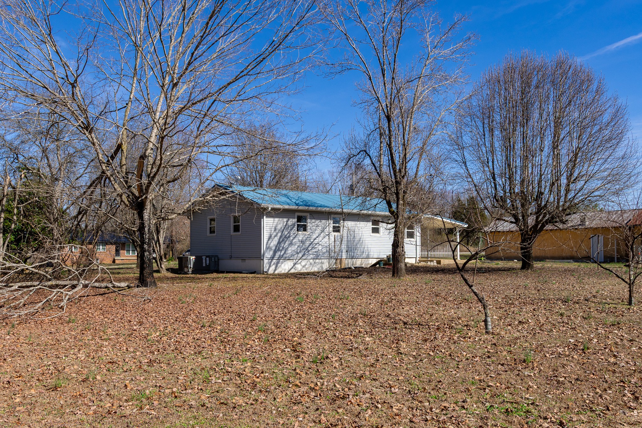 674 Switzerland Road Hohenwald, TN 38462 - Photo 5 of 38 a white house that has a tree in front of it