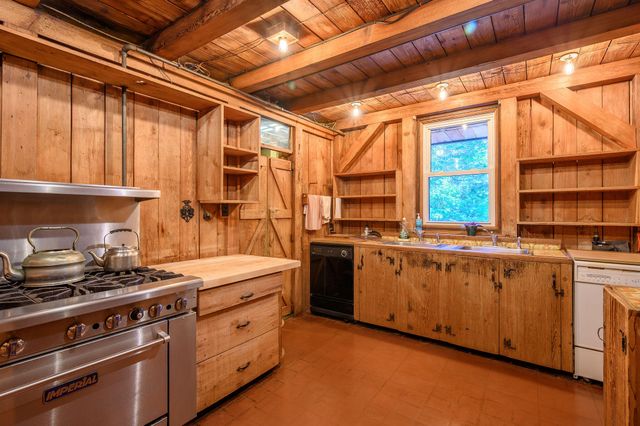 a kitchen with stainless steel appliances granite countertop a sink a stove and a wooden floors