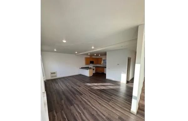 a view of a living room with a sink and wooden floor