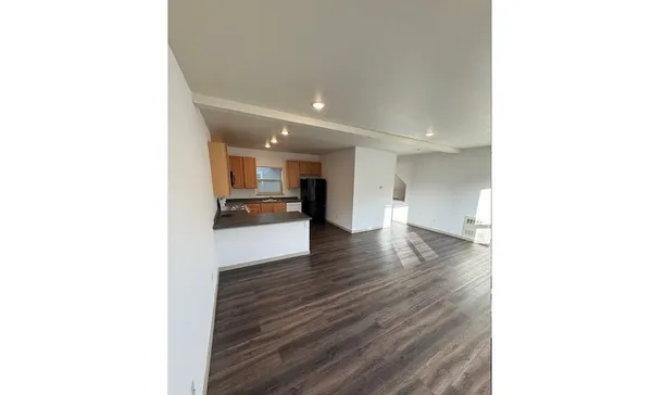 a view of a living room with kitchen and furniture