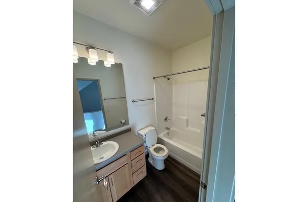 a bathroom with a granite countertop toilet a sink and bathtub