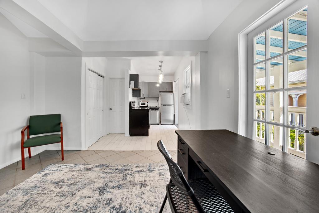 623 Thomas Street, Unit C Key West, FL 33040 - Photo 2 of 25 a living room with kitchen island furniture and a table