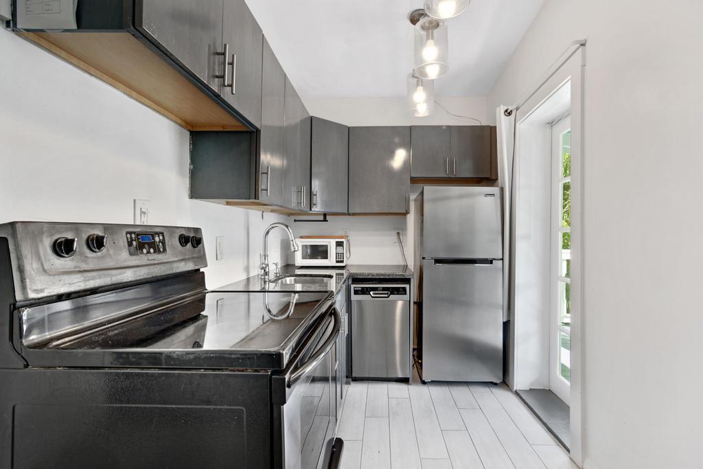 623 Thomas Street, Unit C Key West, FL 33040 - Photo 9 of 25 a kitchen with a refrigerator a stove and a wooden floor