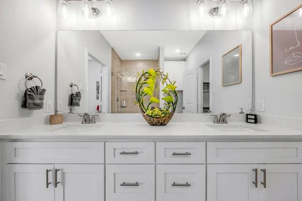 a bathroom with double vanity sinks and a mirror