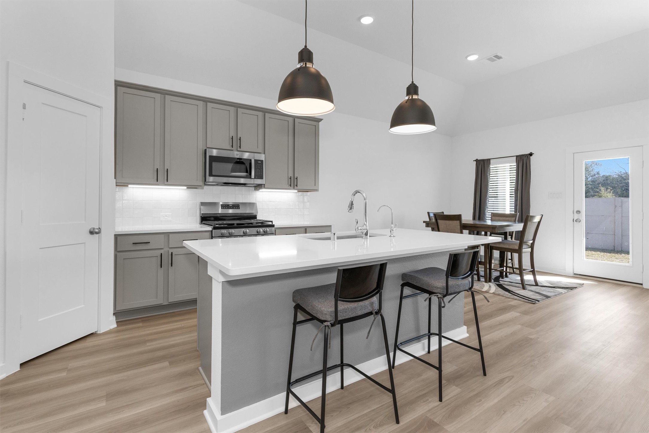 2127 Heather Rdg Way Rosenberg, TX 77471 - Photo 11 of 41 a kitchen with stainless steel appliances granite countertop a stove a sink dishwasher a refrigerator and a dining table with wooden floor