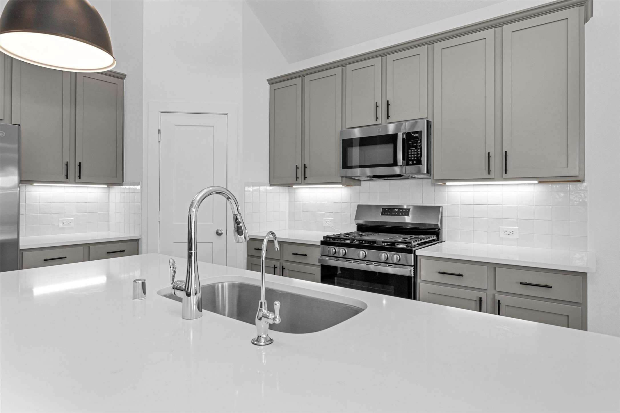 2127 Heather Rdg Way Rosenberg, TX 77471 - Photo 14 of 41 a kitchen with granite countertop a stove a microwave a sink and cabinets