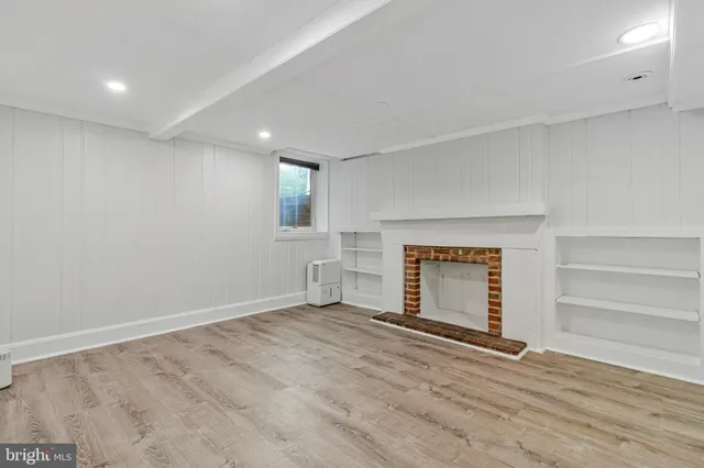 a view of an empty room with a fireplace and a window