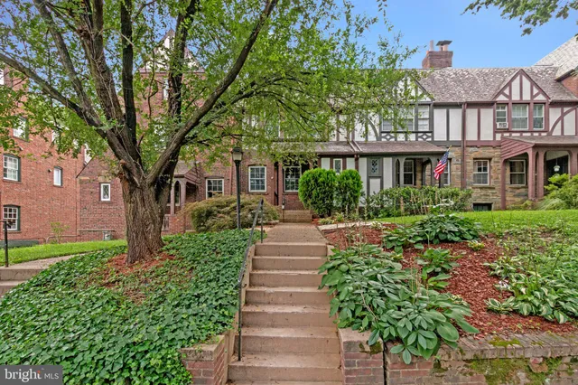 a front view of a house with a garden and plants
