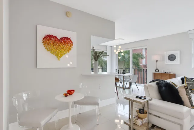 a dining room with furniture large windows and a chandelier