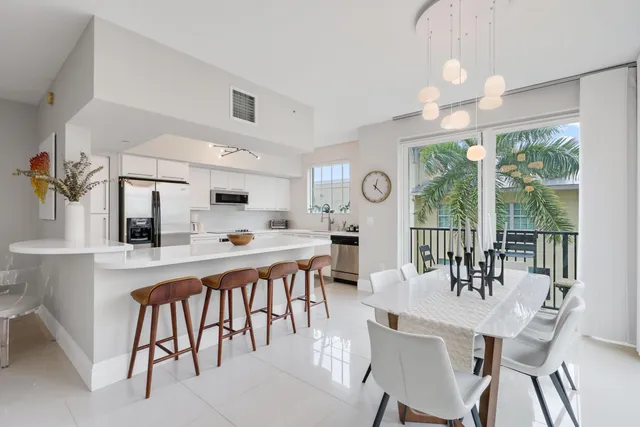a dinning room with stainless steel appliances kitchen island a table and chairs