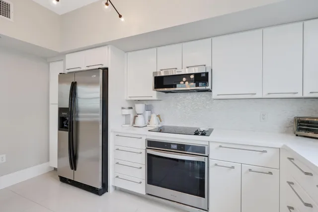 a kitchen with cabinets appliances a sink and a window