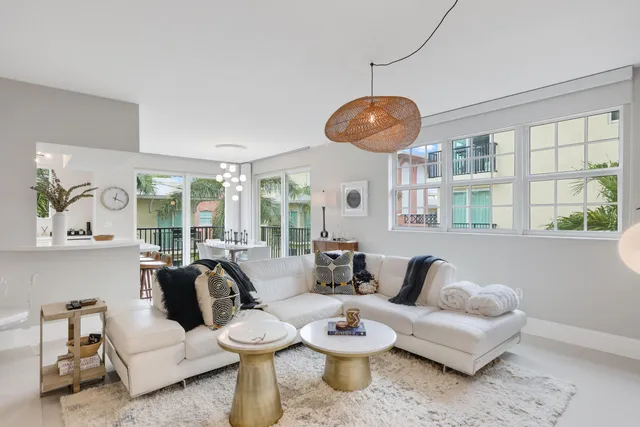 a living room with furniture kitchen view and a large window