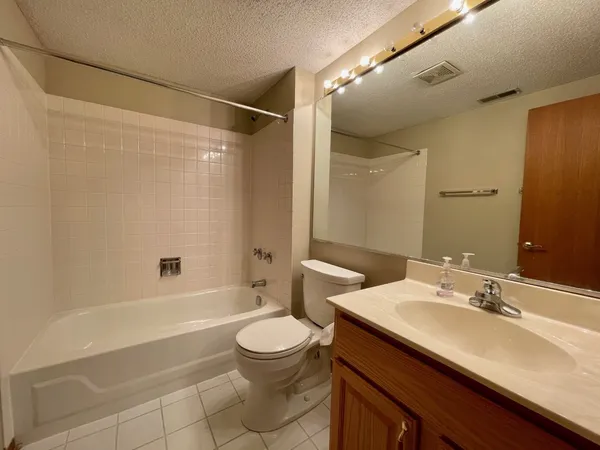 a bathroom with a sink a toilet a mirror and shower