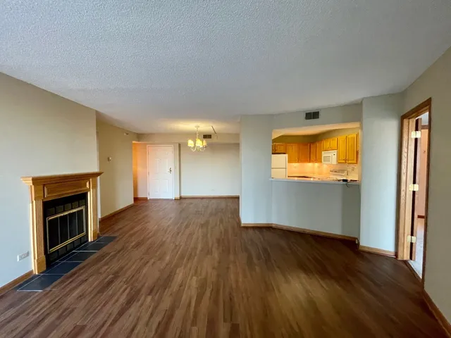 a view of empty room with wooden floor and fireplace