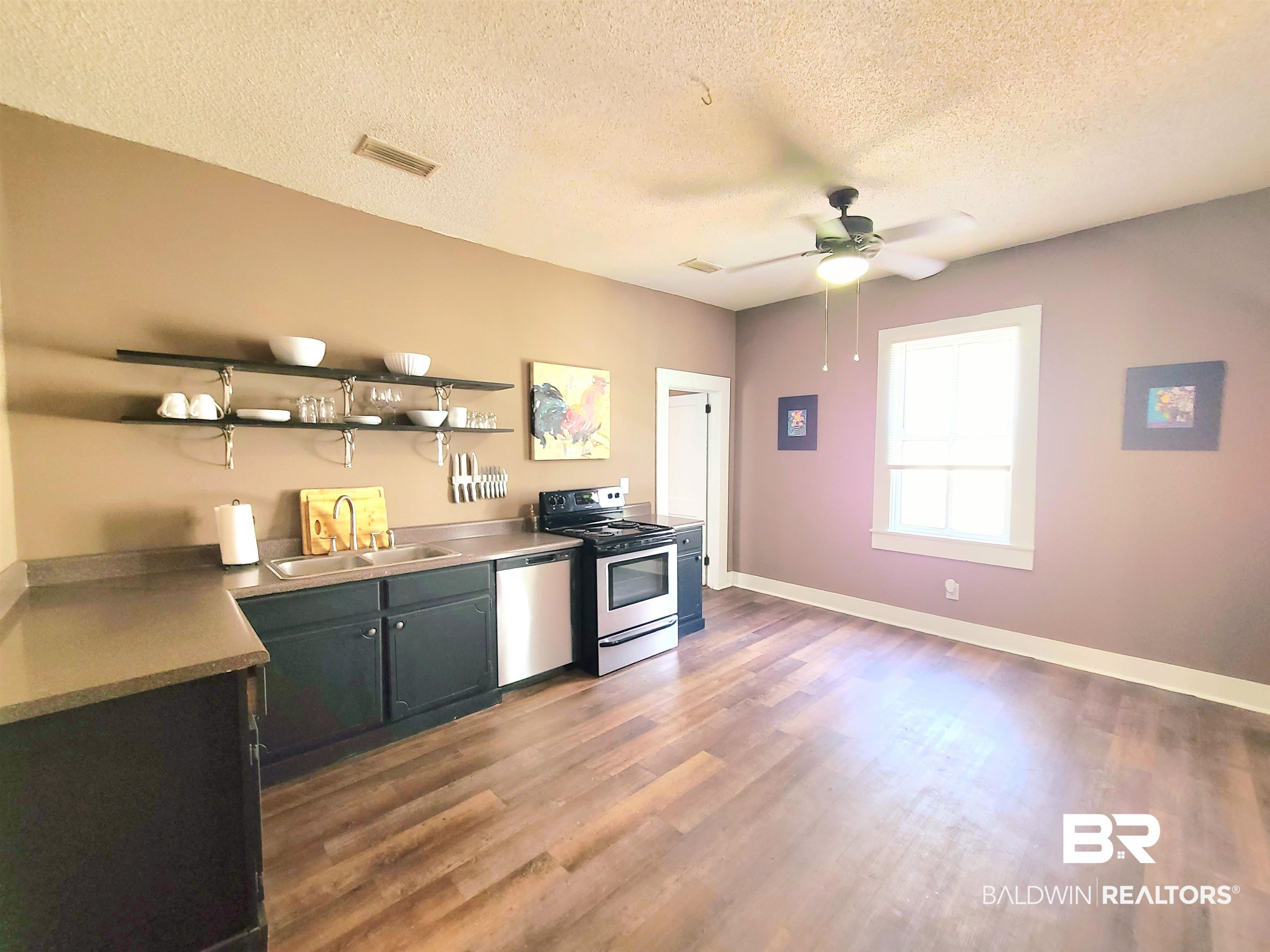 112 Espejo Street Mobile, AL 36604 - Photo 5 of 20 Kitchen featuring a sink, visible vents, a textured ceiling, appliances with stainless steel finishes, and wood finished floors