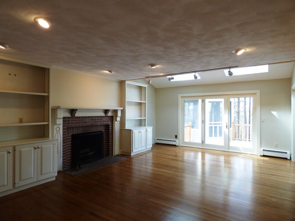 171 West Bare Hill Road Harvard, MA 01451 - Photo 12 of 30 an empty room with wooden floor fireplace and windows