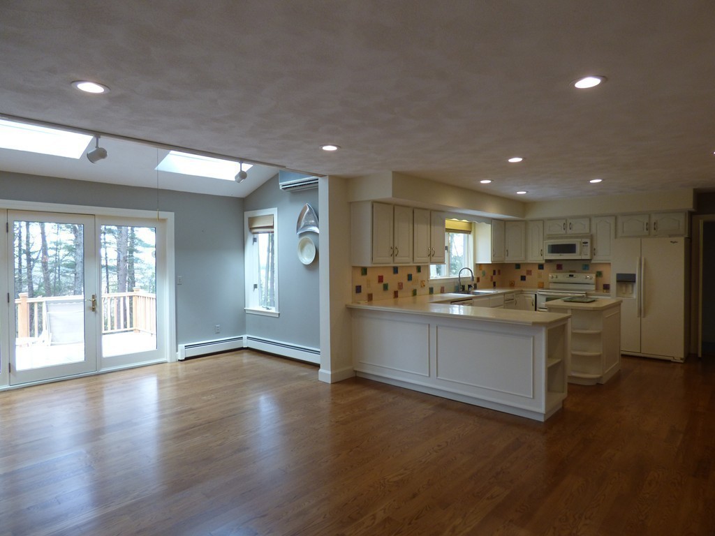 171 West Bare Hill Road Harvard, MA 01451 - Photo 16 of 30 a open kitchen with stainless steel appliances granite countertop a stove top oven a sink dishwasher a refrigerator and white cabinets with wooden floor