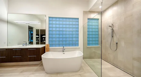 a bathroom with a tub sink shower and mirror