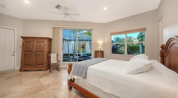 a bedroom with a bed a table and large window