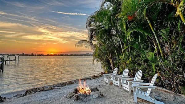a view of a terrace with lawn chairs and iron fence