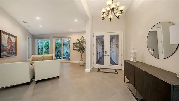 a living room with furniture a large window and a chandelier