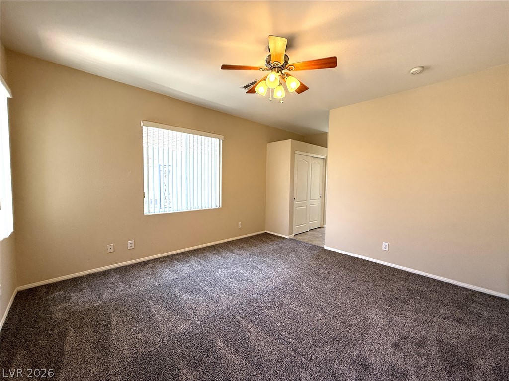 5942 Rampolla Drive Las Vegas, NV 89141 - Photo 13 of 27 A comfortable bedroom features plush carpeting and a ceiling fan, offering a cozy retreat.