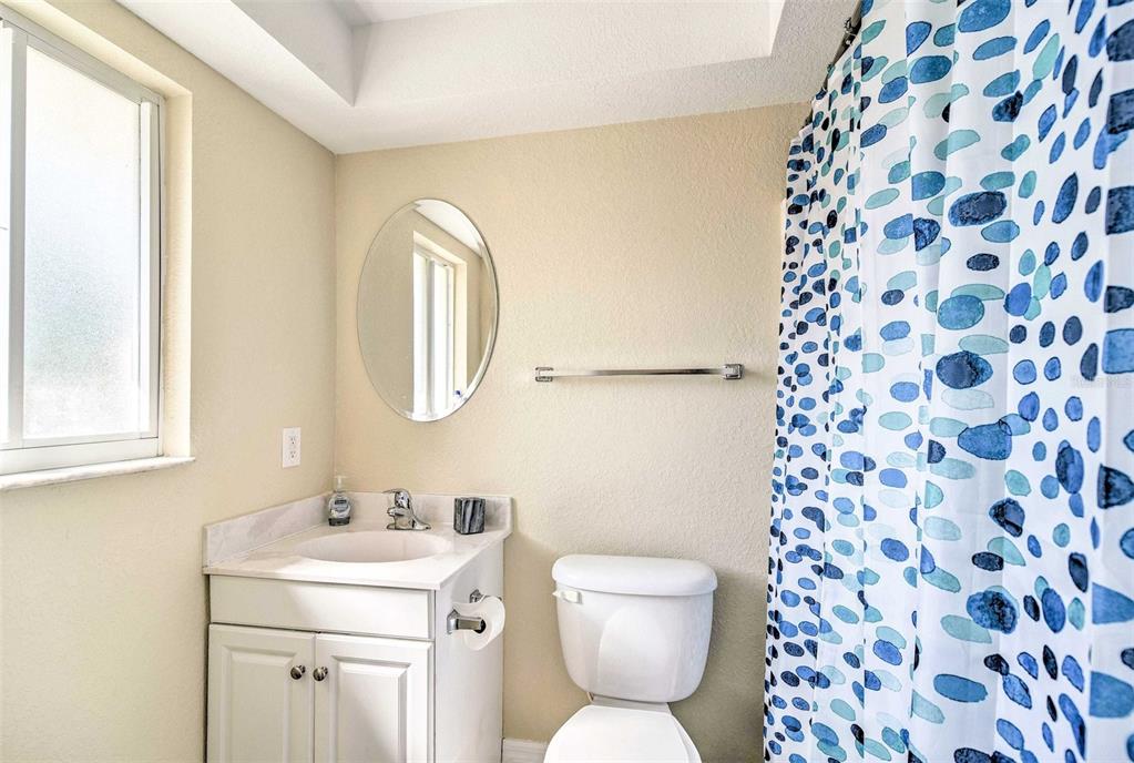2704 2nd Street, Unit 14 Indian Rocks Beach, FL 33785 - Photo 11 of 21 a bathroom with a toilet sink and mirror