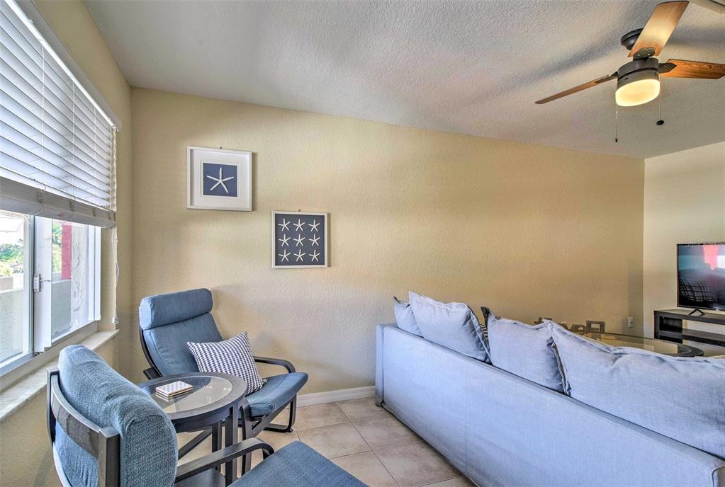 2704 2nd Street, Unit 14 Indian Rocks Beach, FL 33785 - Photo 6 of 21 a living room with furniture and a flat screen tv