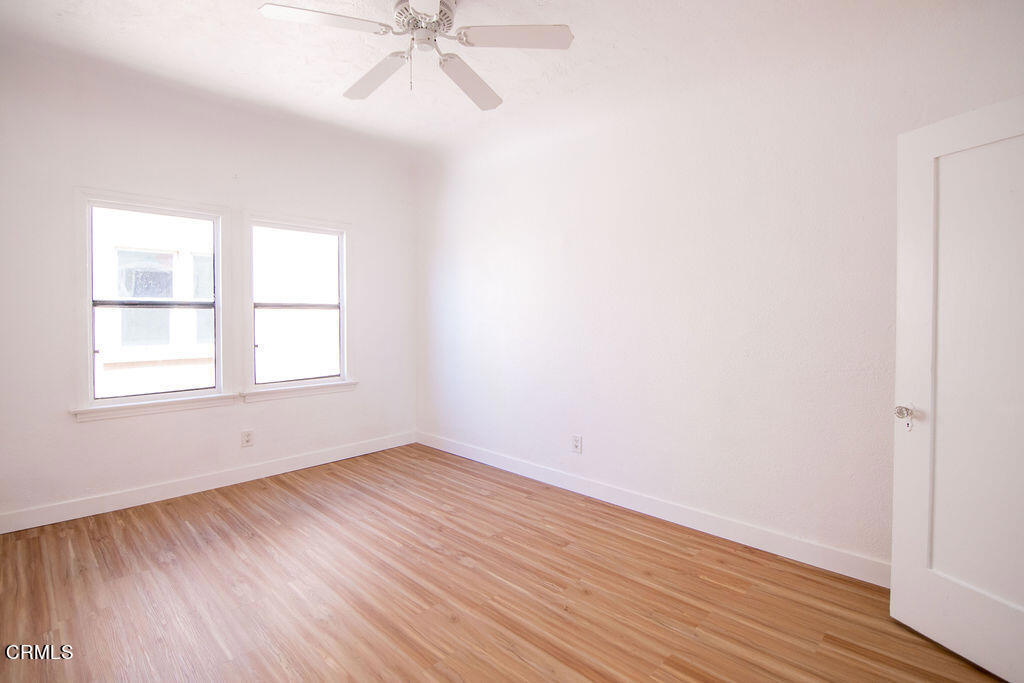 5166 Packard Street Los Angeles, CA 90019 - Photo 29 of 31 an empty room with wooden floor fan and windows