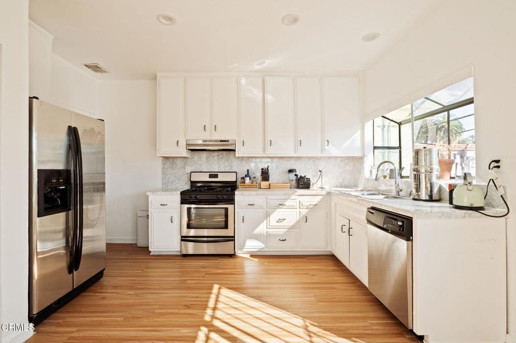 5166 Packard Street Los Angeles, CA 90019 - Photo 8 of 31 a kitchen with granite countertop a refrigerator stove top oven and sink
