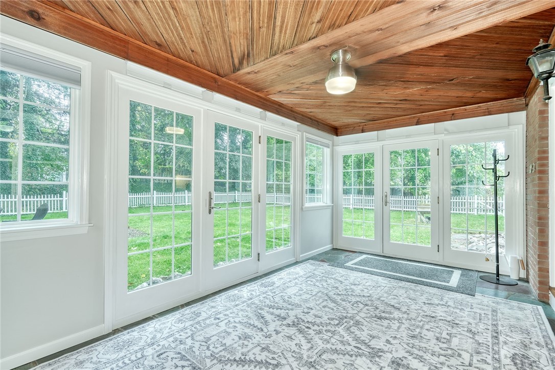 255 Fairport Road East Rochester, NY 14445 - Photo 19 of 26 Rich wood plank ceilings and walls of glass doors define this versatile sunroom space.