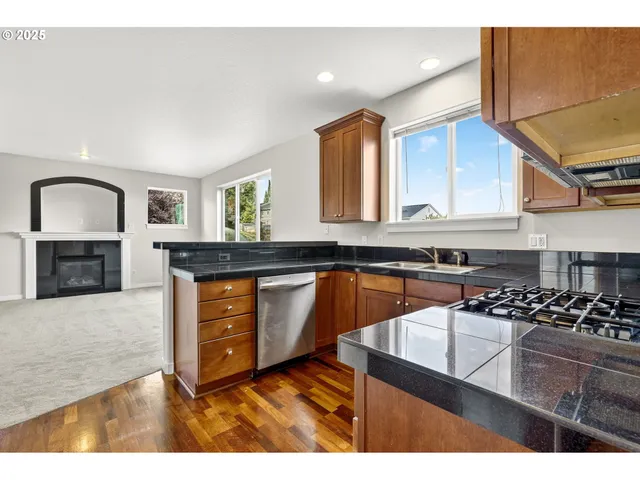 a kitchen with stainless steel appliances granite countertop a sink a stove and cabinets
