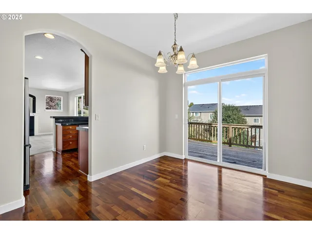 an empty room with wooden floor and large windows