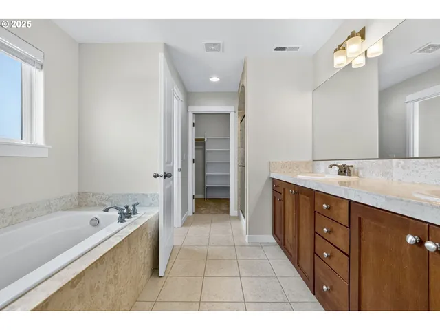 a bathroom with a sink a large mirror and a bathtub