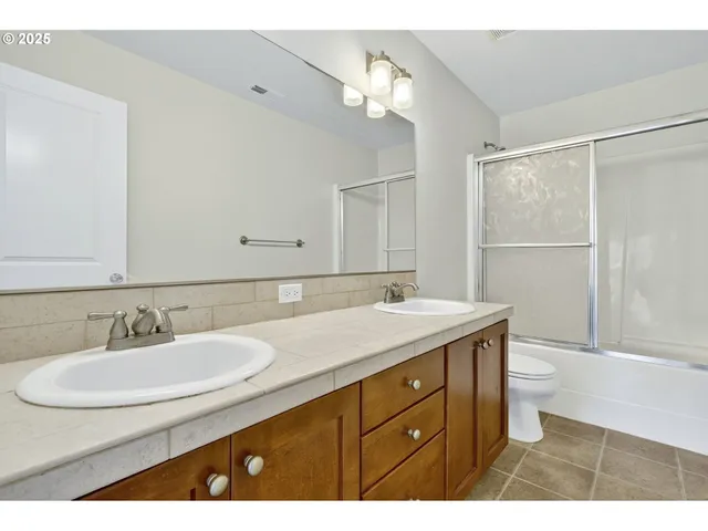 a bathroom with a granite countertop sink a toilet and a mirror